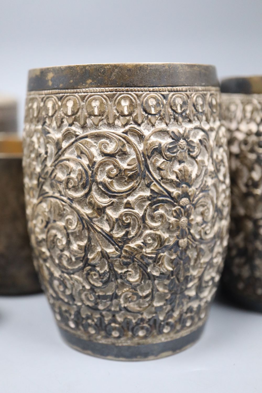 Three Indian repousse white metal beakers, 97mm and six other items including sterling mug and 800 salt.